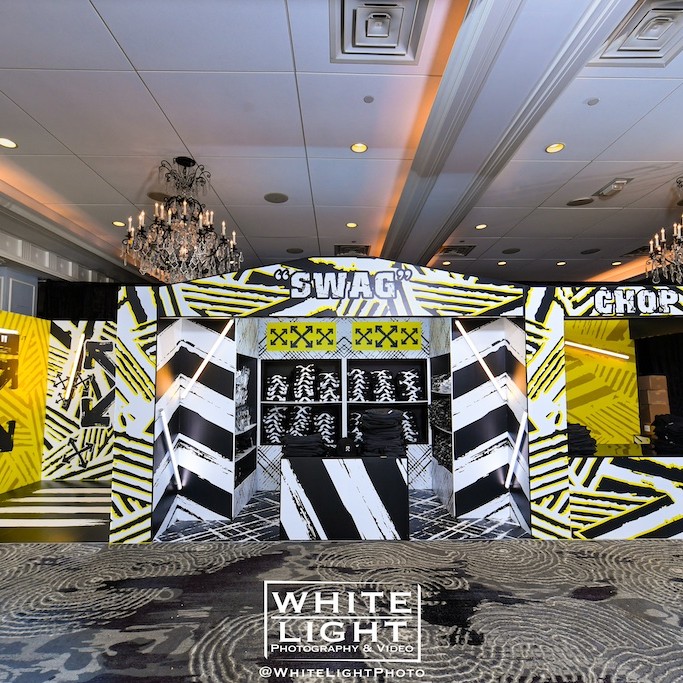 Event room with a black and yellow themed booth labeled 