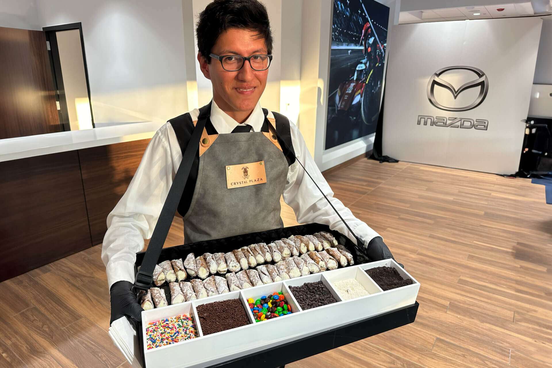 Guests at the Wayne Mazda ribbon cutting enjoy make your own cannolis.
